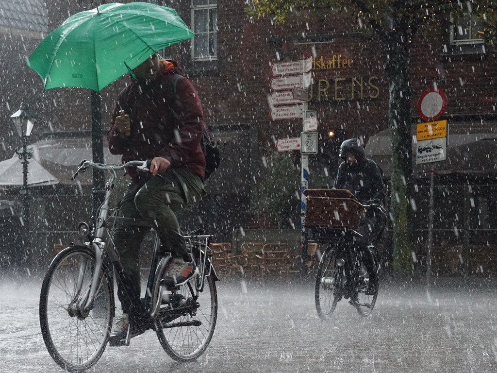 Rowerem po chodniku w deszczu